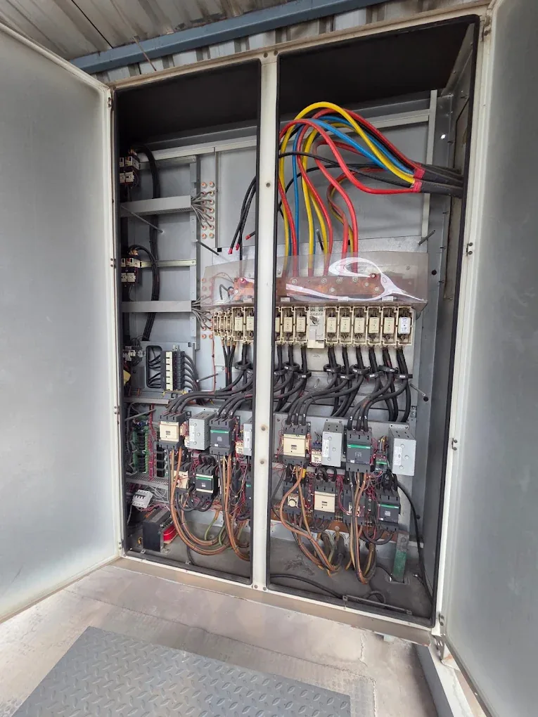 Open electrical control cabinet with wiring, contactors and fuses