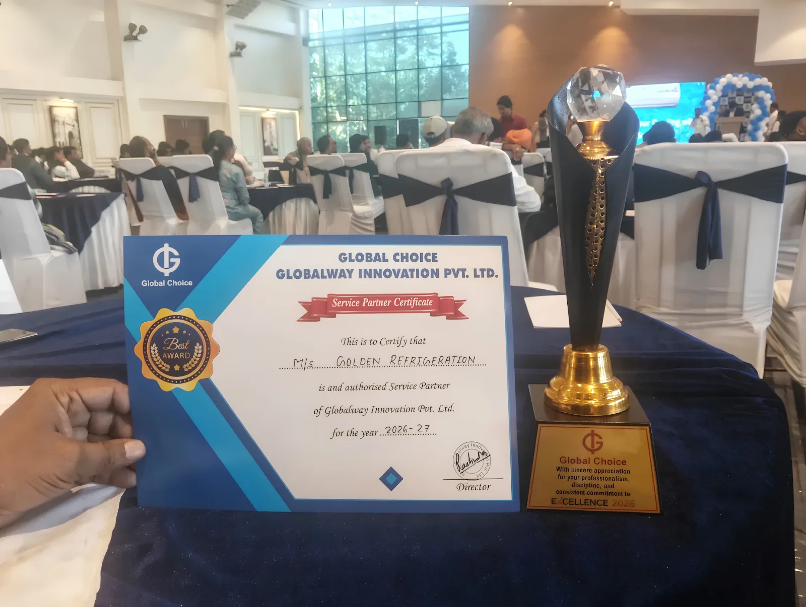 Golden Refrigeration’s 2026–27 Globalway Innovation authorised service partner certificate beside a Global Choice excellence trophy